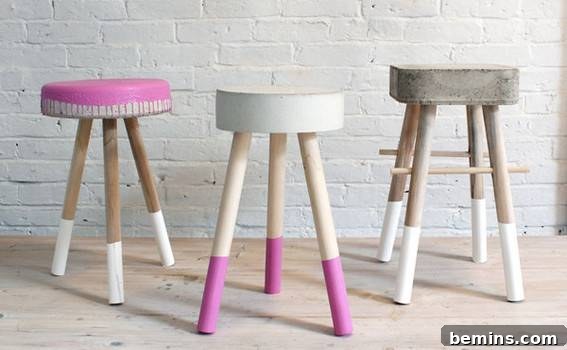 Three stools styled with the colors pink, white, and grey.