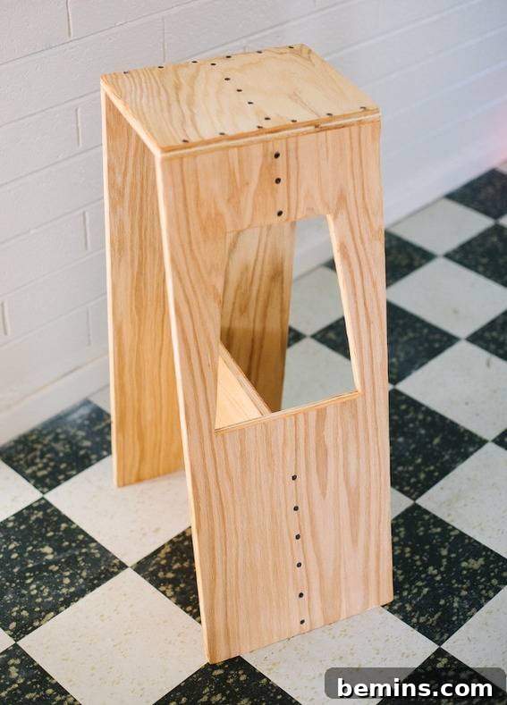 Stylish Seating: 12 DIY Stool and Bench Projects 13 Stylish stool with hole in flat checked surface.