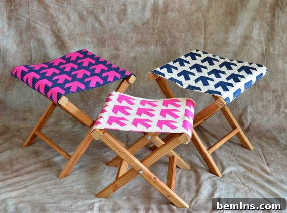 Three wooden seats, one blue one with pink arrows, one white one with pink arrows and one white wone with blue arrows.