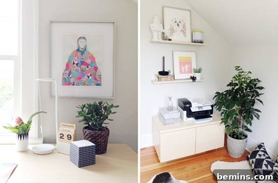 A piece of art woth a woman in a multicolor pink, blue and grey above a number 29 on a desk and two shelves with a picture on each flanked with chatchkies above a printer on a cream cupboard next to a potted tree.
