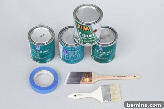 Four paint cans, a roll of blue painters tape, and two paint brushes.