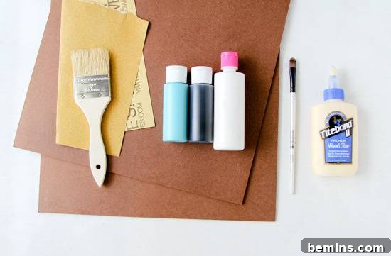 Paint brushes and paint bottles on construction paper.