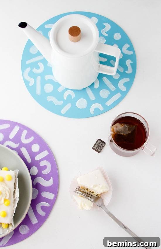 Tea warmer, tea, and petite four on decorative circles.
