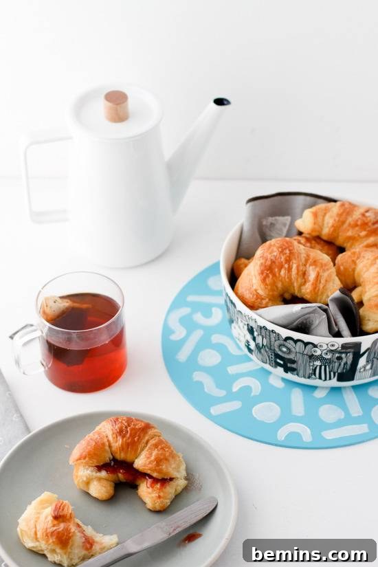 Table setting with croissants and tea.
