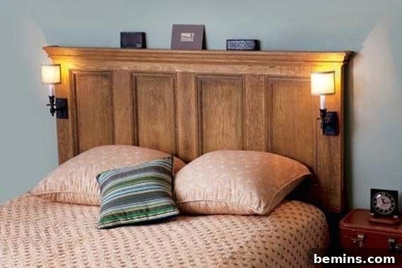 A bed has a wooden headboard and peach colored sheets.