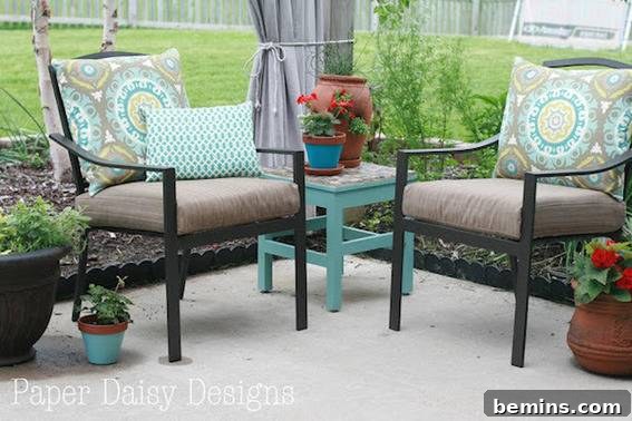 A patio has two chairs and a teal end table.