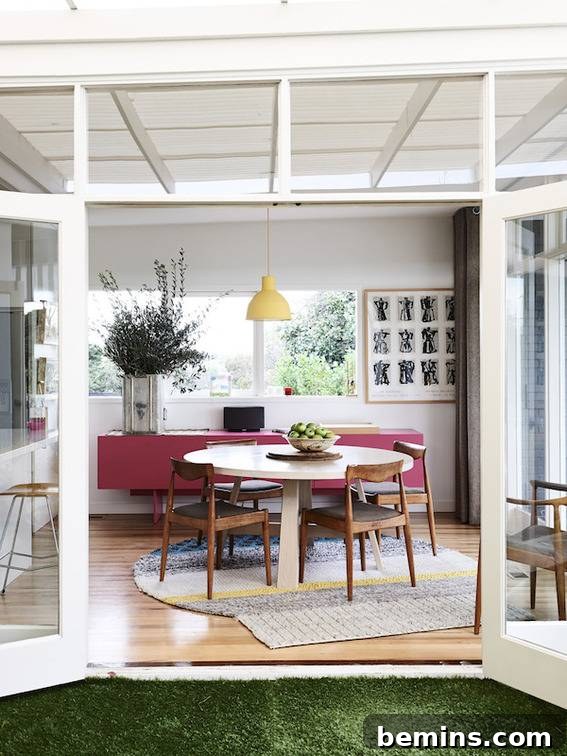 A white room featuring red accent furniture and a vibrant green turf rug.