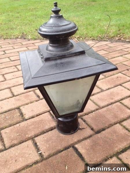Outdoor wall lamp lantern on the floor, a stark contrast to its revitalized state.