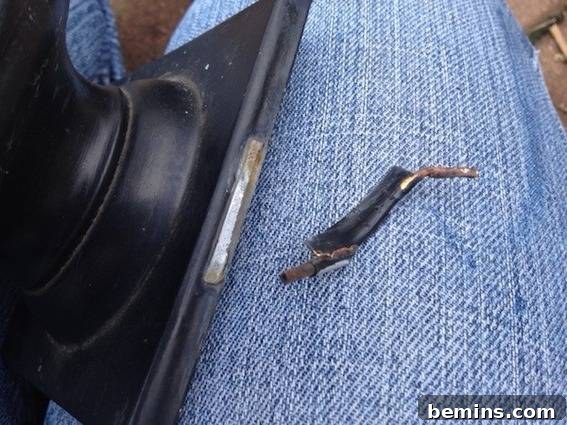 A broken wire is sitting on someone's blue jeans, highlighting the need for careful removal and replacement.