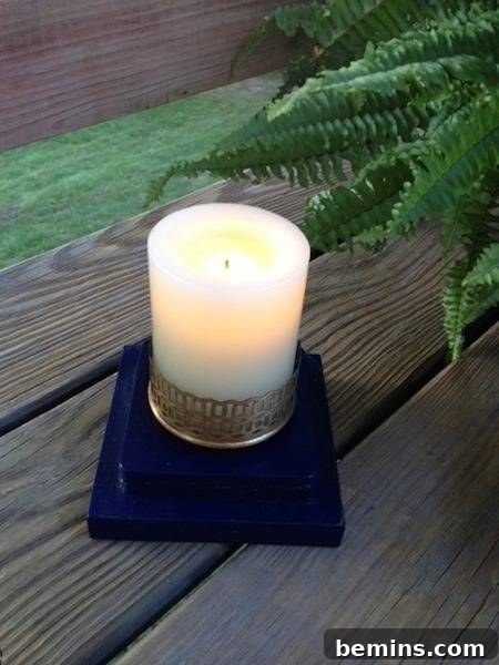 A small candle sits on a dark blue base on a wooden surface, illuminating the lantern's new function.