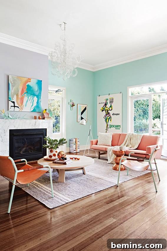 A vibrant living room featuring wooden floors, eye-catching orange chairs, and refreshing light blue walls.