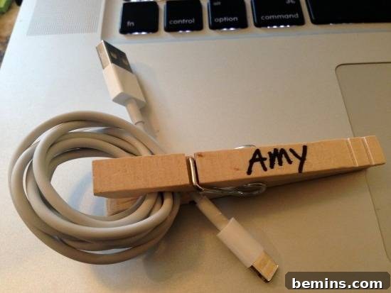 A clothes pin with the name Amy on it is clipped around a usb cable.
