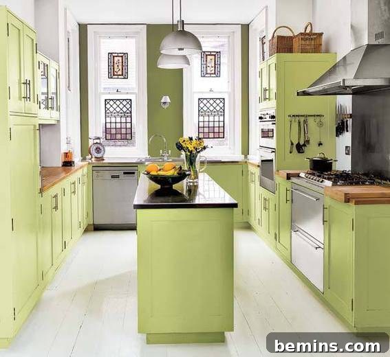 An olive green kitchen with a bowl of lemons on the island.