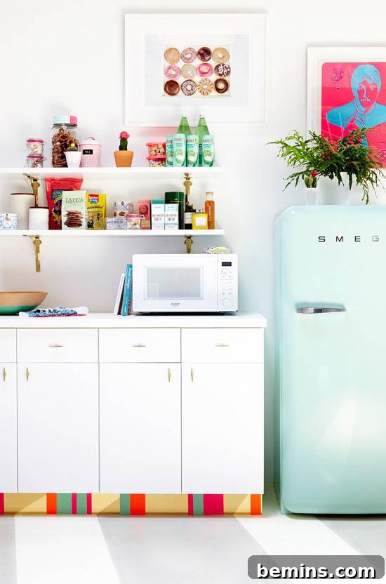 A kitchen has white cabinets and a light teal refrigerator.