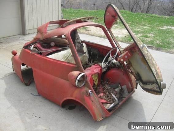Corked Cruisin': The Ultimate Wine Cork Car 3 Vintage car parts scattered on a driveway, showcasing the initial state of disrepair before restoration.