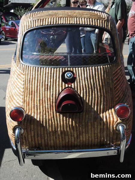 Corked Cruisin': The Ultimate Wine Cork Car 6 A small antique car with a wooden exterior covered in wine corks, highlighting the texture and craftsmanship.