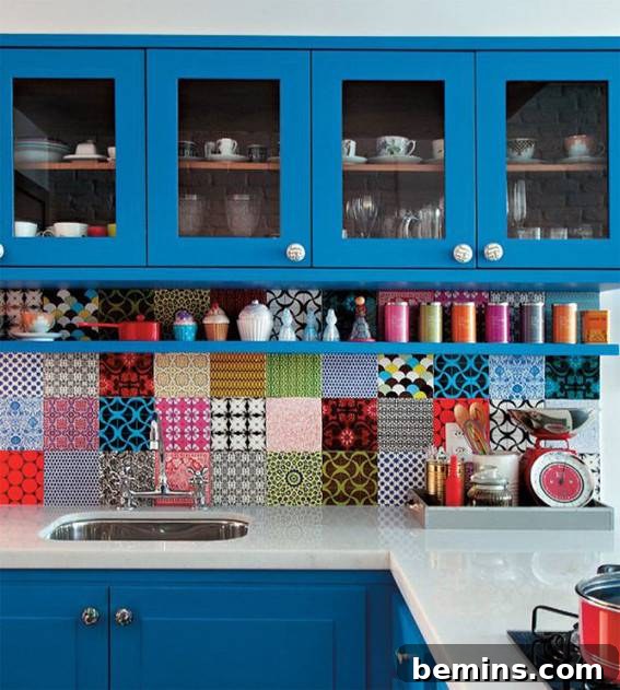 A blue kitchen has colorful patches of backsplash on the wall.