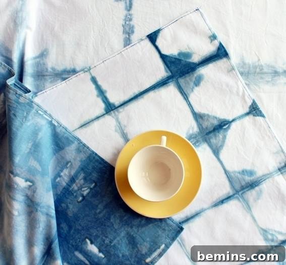 Culinary Creations: 16 Fabric DIY Projects for Home Chefs 14 A cup of tea resting on a dish, placed on a beautifully patterned checkered shibori tablecloth.