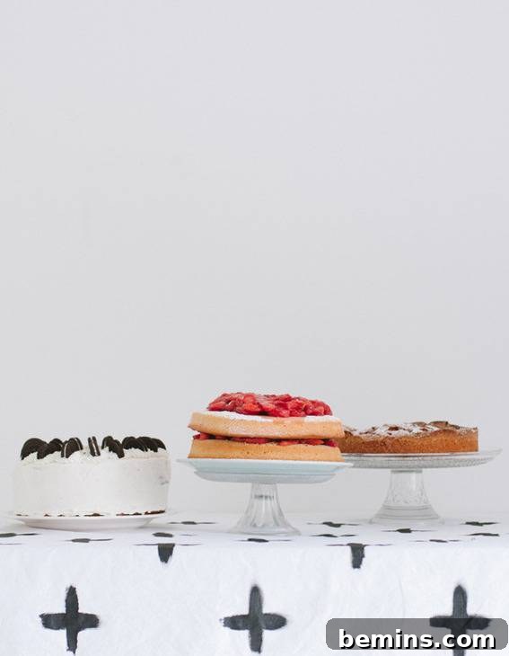 Culinary Creations: 16 Fabric DIY Projects for Home Chefs 18 A trio of cakes displayed on a table with a striking black and white hand-painted tablecloth.