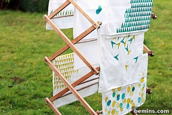 Culinary Creations: 16 Fabric DIY Projects for Home Chefs 3 A stylish wooden blanket rack displaying white and green hand-printed tea towels.