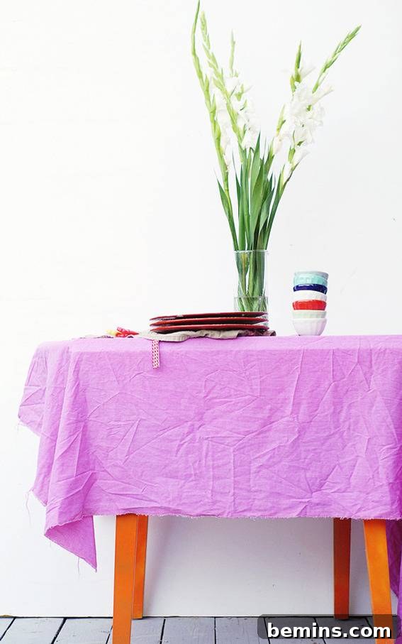 Culinary Creations: 16 Fabric DIY Projects for Home Chefs 9 A vibrant green plant sitting on a table covered with a purple chiffon veggie-dyed tablecloth.