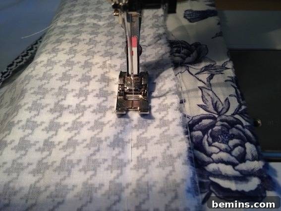 Double the Seating: A DIY Stool Split 11 Houndstooth fabric folded underneath the presser foot of a sewing machine. Close up of the sewing process.