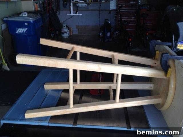 Double the Seating: A DIY Stool Split 3 Stool clamped sideways to a workbench for cutting. Demonstrating the cutting process of the stool.