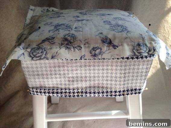 Double the Seating: A DIY Stool Split 10 Blue and white floral fabric on top of a houndstooth fabric, covering a white-painted stool. Showcasing the mixed fabric prints.