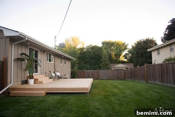 From Cluttered to Chic: A Backyard Deck Transformation 13 View of the light brown house with the newly fenced backyard.
