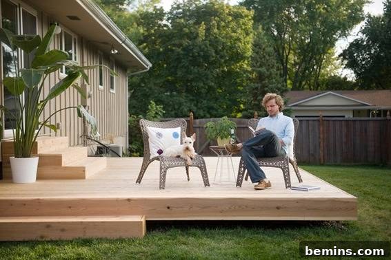 From Cluttered to Chic: A Backyard Deck Transformation 16 Man and dog sitting on the chair in the backyard.