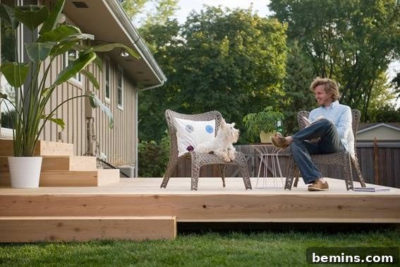 From Cluttered to Chic: A Backyard Deck Transformation 19 A man sitting next to a dog on the back porch, enjoying the new deck.