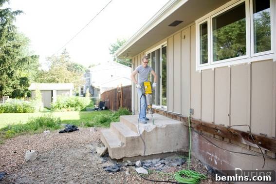 From Cluttered to Chic: A Backyard Deck Transformation 8 Jeff posing with a tool on the concrete porch steps, ready to start the makeover.