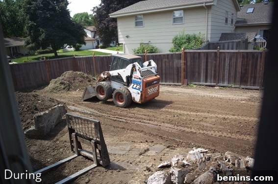 From Cluttered to Chic: A Backyard Deck Transformation 9 A bobcat moving dirt in the barren backyard during the excavation process.