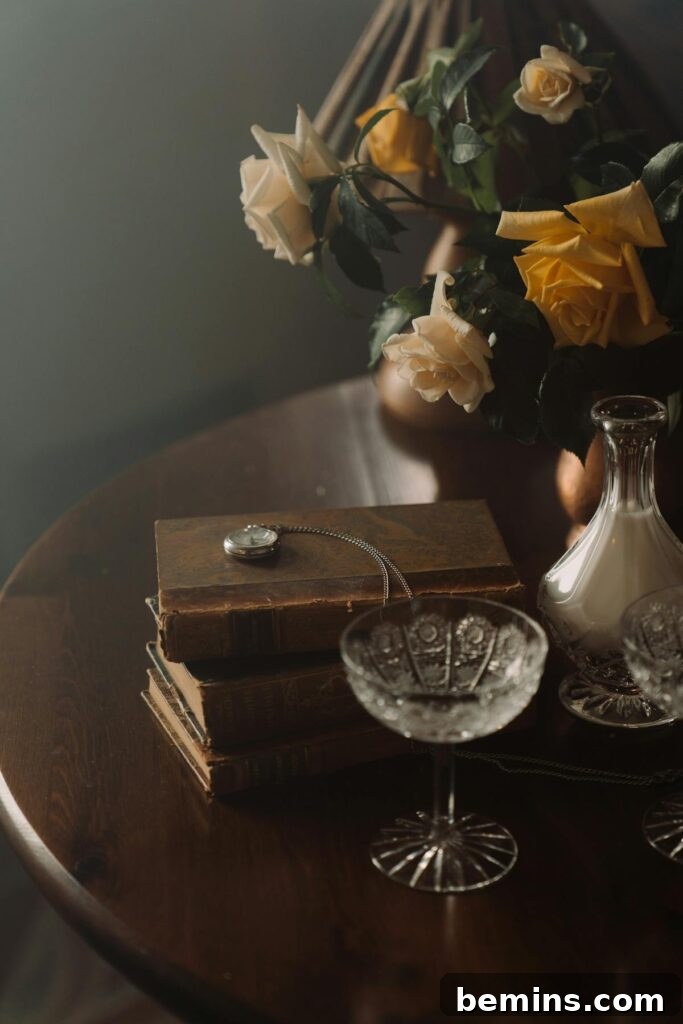A serene still life featuring vintage books, a pocket watch, and a bouquet of roses on a wooden table.