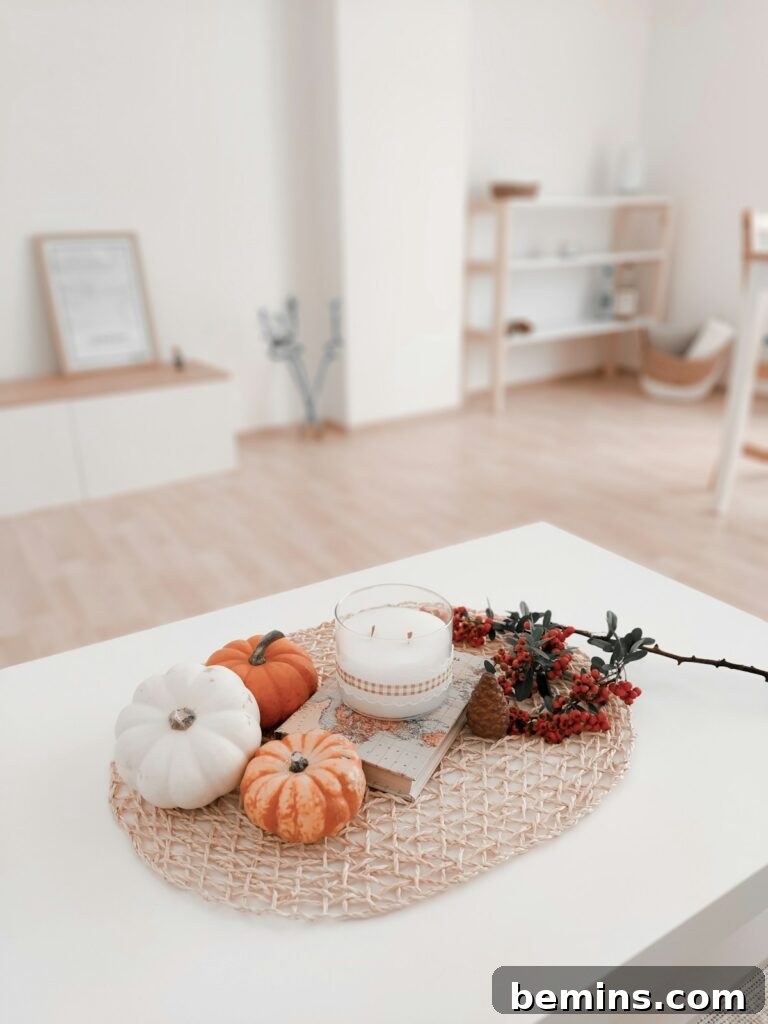 a white table topped with pumpkins and a candle