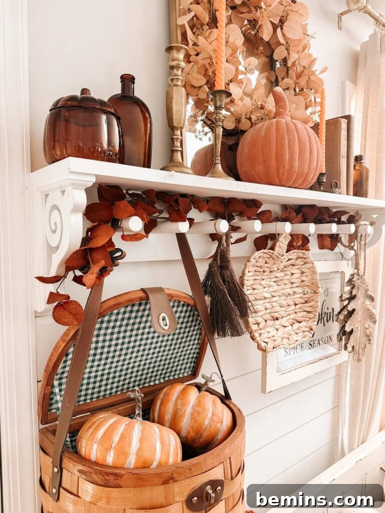 Wall shelf with amber glass bottles shaped liked pumpkins and other fall decor