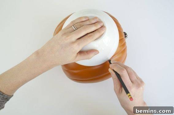Tracing a circle on a craft pumpkin.