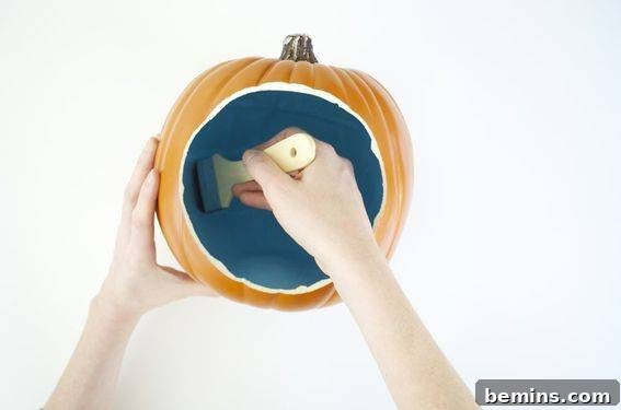 Painting the interior of the pumpkin with acrylic paint.