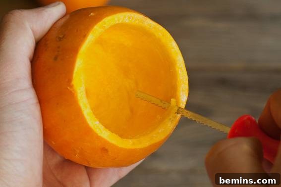 Smoothing the inner rim of a pumpkin cup with a knife for a more comfortable drinking experience.