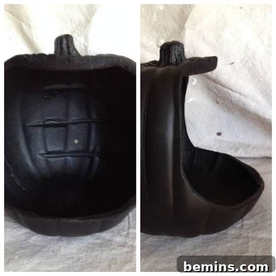 A black plastic pumpkin has been cut out of.
