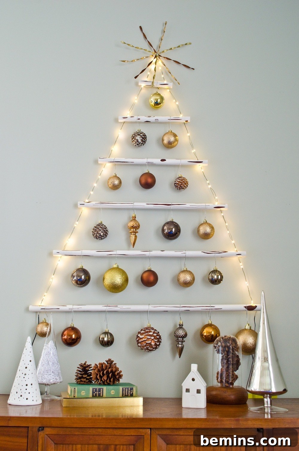 Shelves on wall made to look like Christmas tree with ornaments, lights, and a star.
