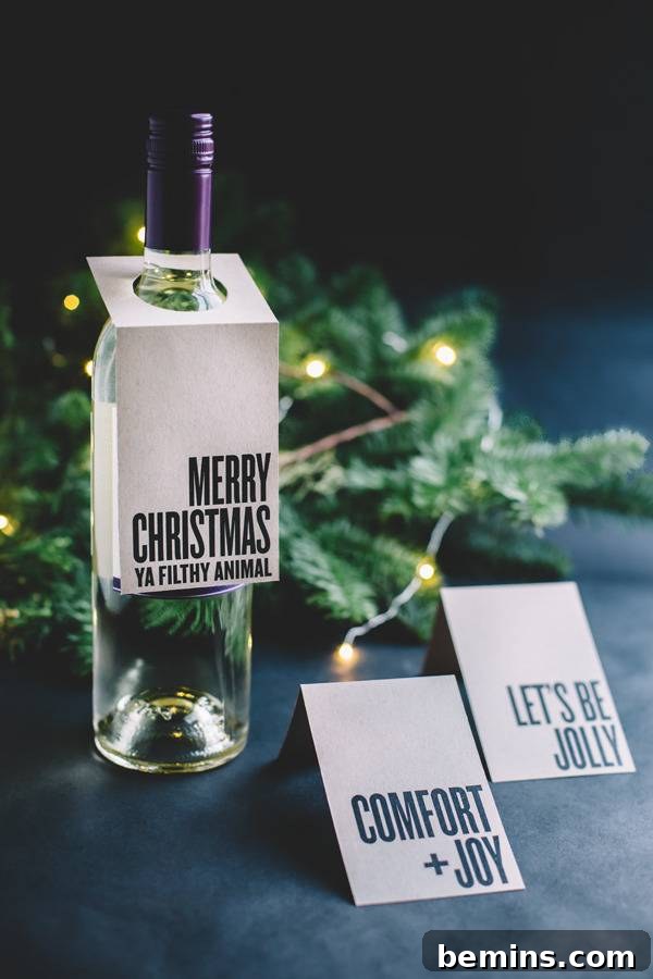 A bottle that has "Merry Christmas" on it in front of a Christmas tree twig, tagged with a free printable Christmas gift tag.