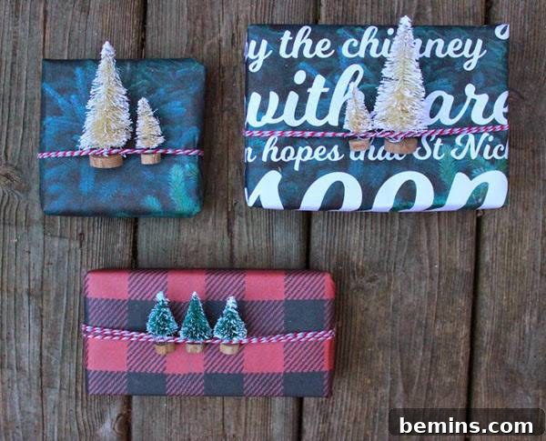 Three wrapped presents with tiny tree decorations tucked under the ribbon.