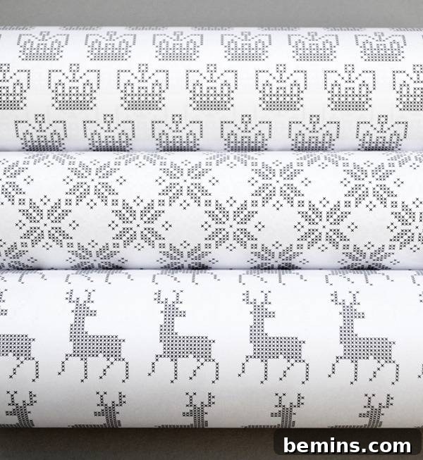 Three rolls of Holiday gift-wrapping, featuring reindeer, snowflake and another design.