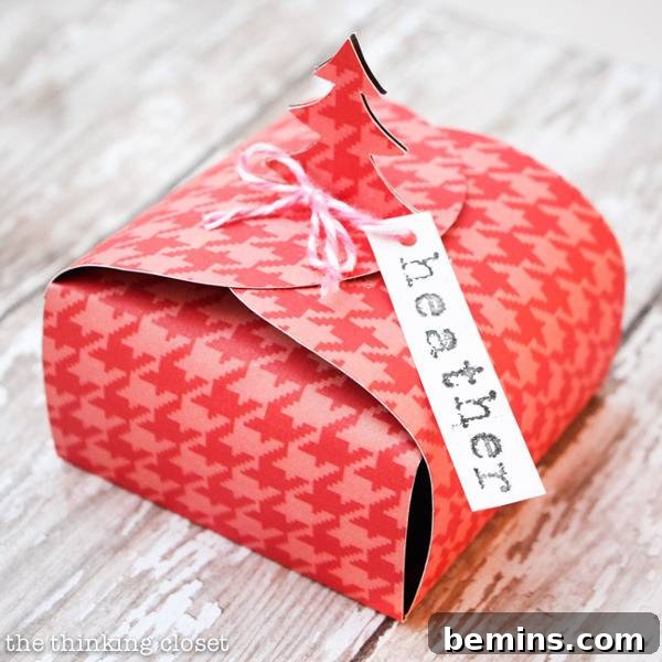 A pink and red houndstooth gift box with a personalized gift tag.