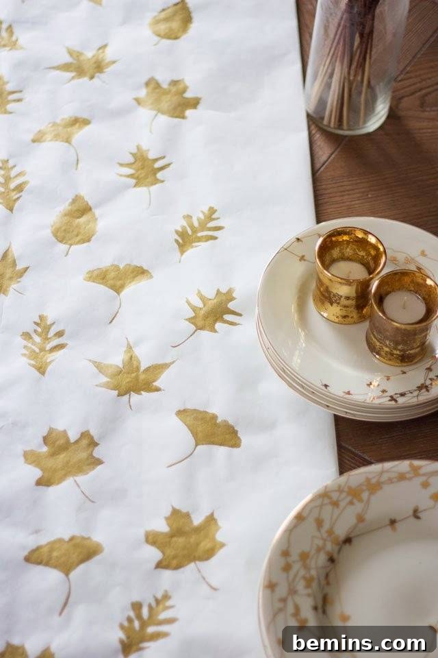 Quick & Easy Thanksgiving Table: 13 DIY Ideas Under an Hour 10 Thanksgiving table runner idea with gold leaves printed on the material.