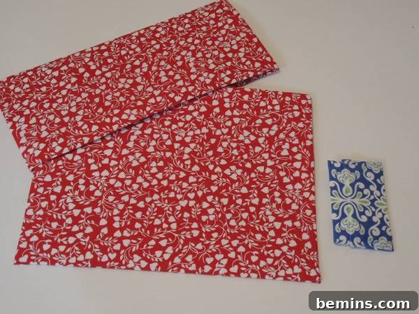 Colorful fabric decorated with hearts and floral design, showcasing the size difference between the small and large fabric envelopes.