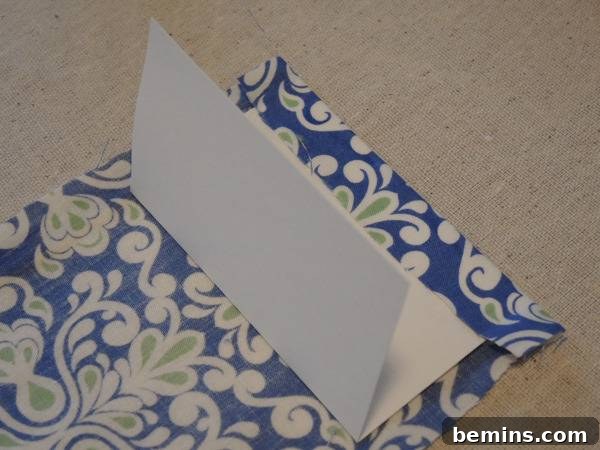 A blue fabric envelope is being put together, demonstrating the re-folding of the poster board.