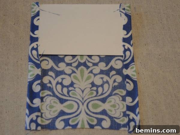 Cardboard is placing in a printed fabric cloth, showing the folding and gluing of the side edges.