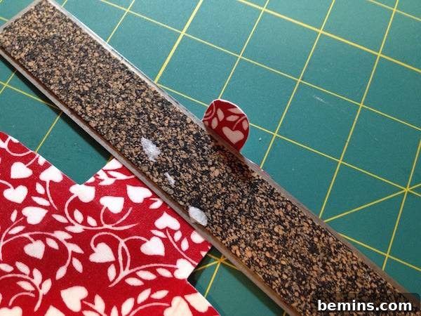 The back of a ruler on top of red and white designed fabric.